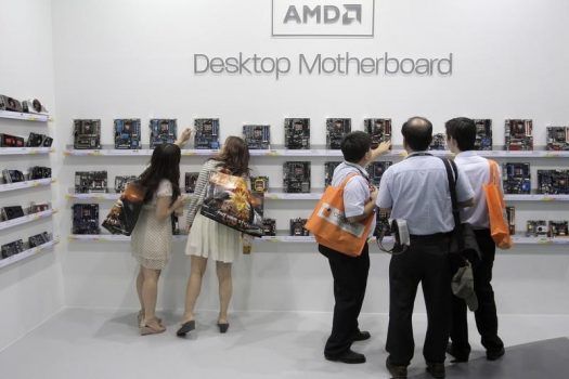 Visitors look at motherboards being displayed at the AMD booth during the 2012 Computex exhibition at the TWTC Nangang exhibition hall in Taipei