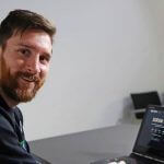 Messi sorrindo computador ao fundo startup israelense