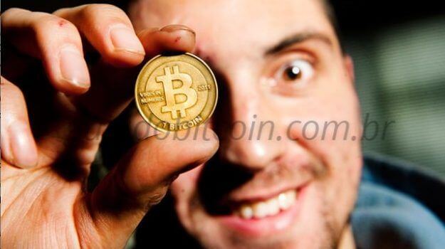 homem segurando bitcoin