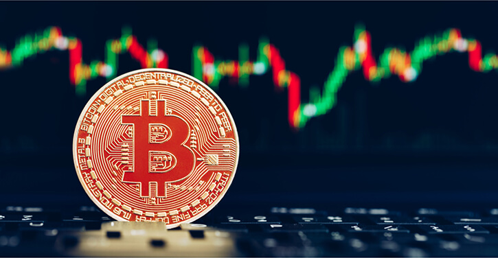 Bitcoin na frente de um gráfico desfocado no fundo