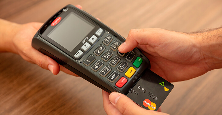 Imagem de um Mastercard sendo usado em um terminal de pagamento POS