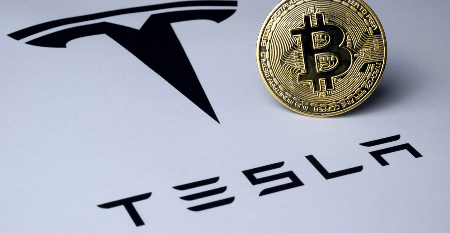 Logotipo do Bitcoin e Tesla visto no papel