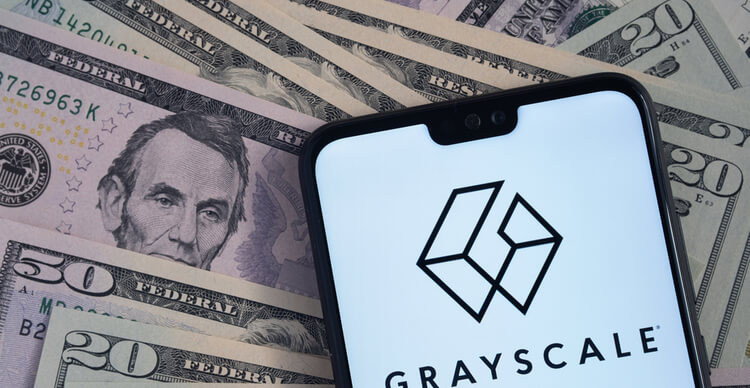 Logotipo da Grayscale em tela de smartphone, sobre notas de dólar