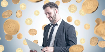 Empresário segurando um laptop sob uma chuva de Bitcoin